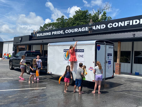 Kids cleaning the Mobile Sports Locker at a Fundraiser
