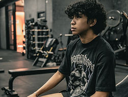 A man sitting on a bench in a gym_edited