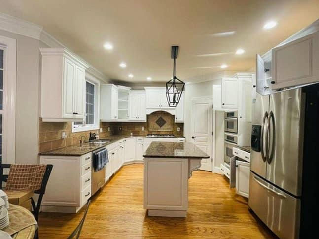Modern kitchen interior featuring sleek cabinets, stainless steel appliances, and a spacious island with bar stools.