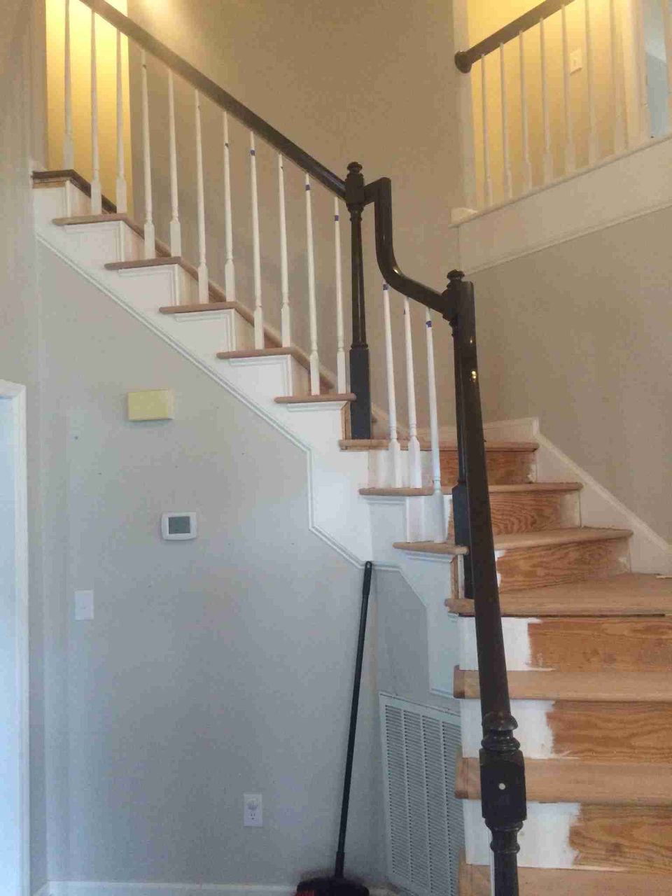 A professional painter applying fresh paint to a wooden staircase, showcasing a vibrant color transformation.
