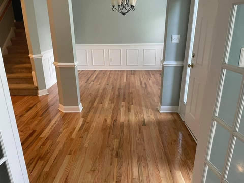 Wide shot of a wooden floor with a warm finish, highlighting its texture and color variations.