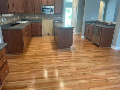 Close-up of a polished wooden floor showcasing rich grain patterns and warm tones in a well-lit interior space.