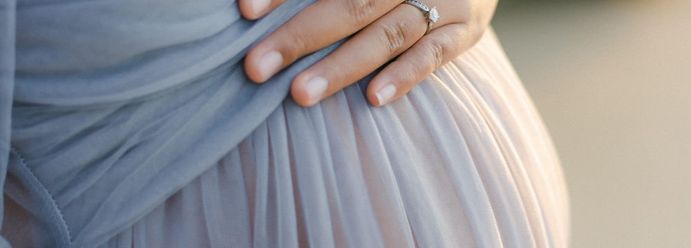 Femme enceinte qui caresse son ventre.