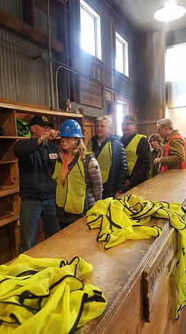 Guests smiling getting suited up for the Copper Queen Mine Tour in Bisbee, Az.