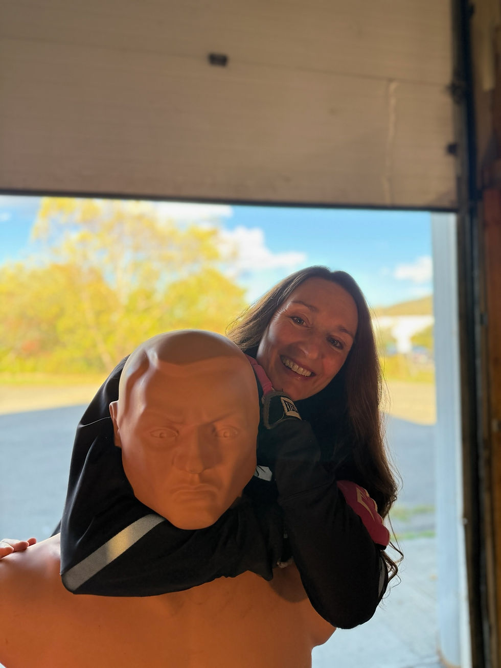 Woman practicing self-defense on a training dummy.