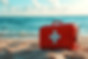 red-first-aid-kit-sandy-beach-with-ocean-background.jpg
