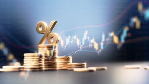 Abstract image showing a subtle upward trend line on a wall with gold coins and a percentage marker in the foreground, representing business financial performance and margins.