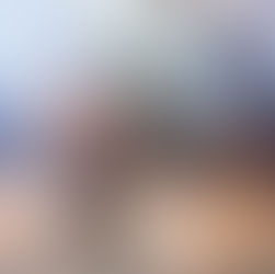 Couple embrace under an umbrella during rain at a wedding venue.