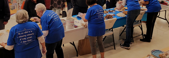 An image of several congregants in blue Newtown United Methodist Church shirts volunteering at our annual craft fair.