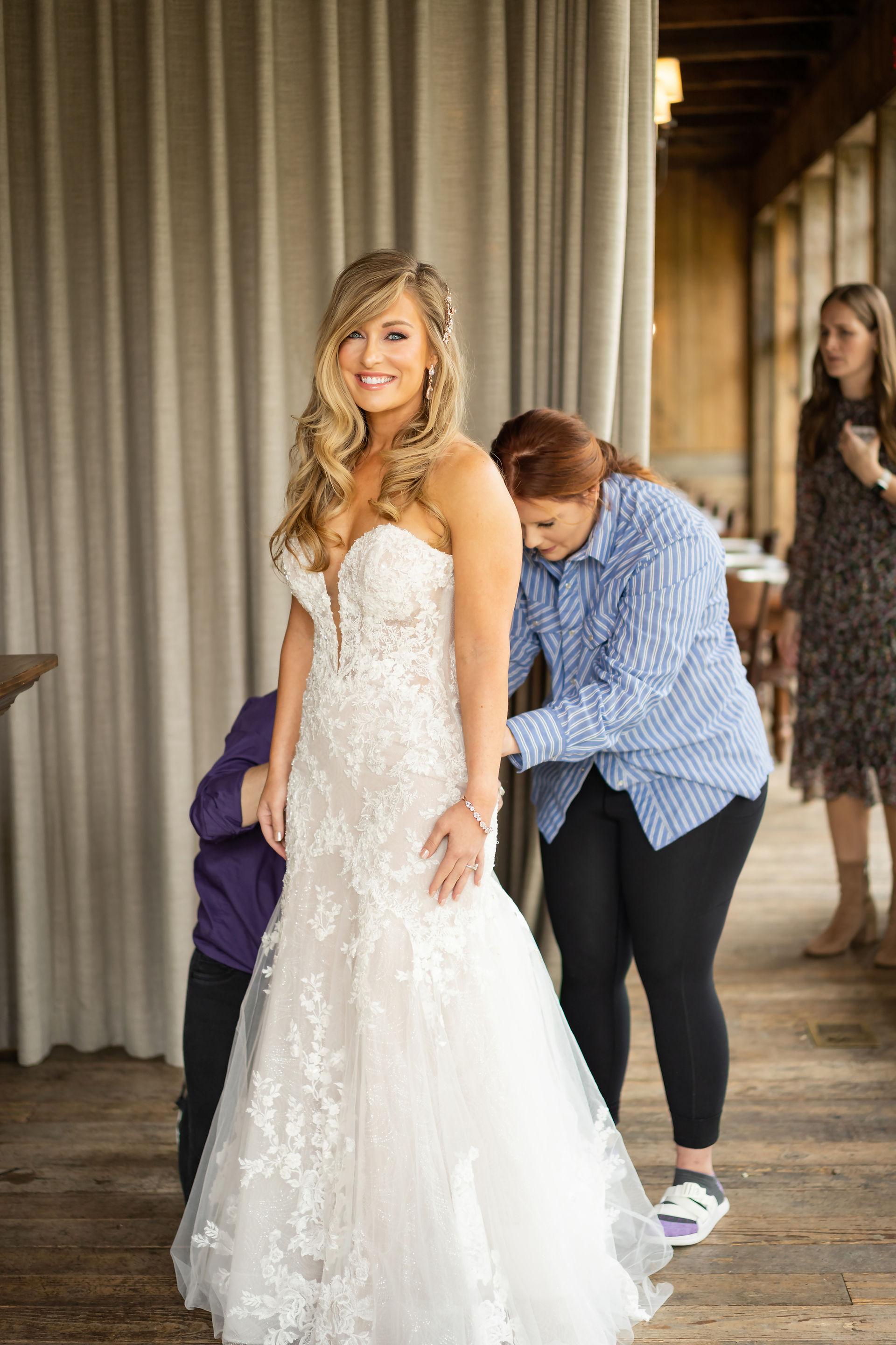 Bride getting zipped into her dress at FInley Farms in Ozark, MO by Lana Raquel Photography