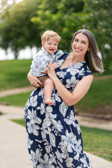Mom with her young son posing in front of flowers and greenery during a family photoshoot in Springfield, Missouri.