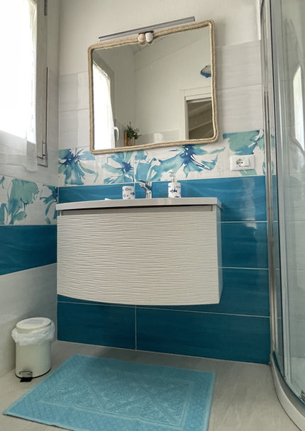 Blue accents and refined touches in the bathroom of Villa Agata, echoing the seaside atmosphere.

