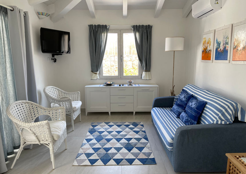 Cozy sitting area at Villa Agata, with natural light and a soft-toned armchair for relaxing moments.