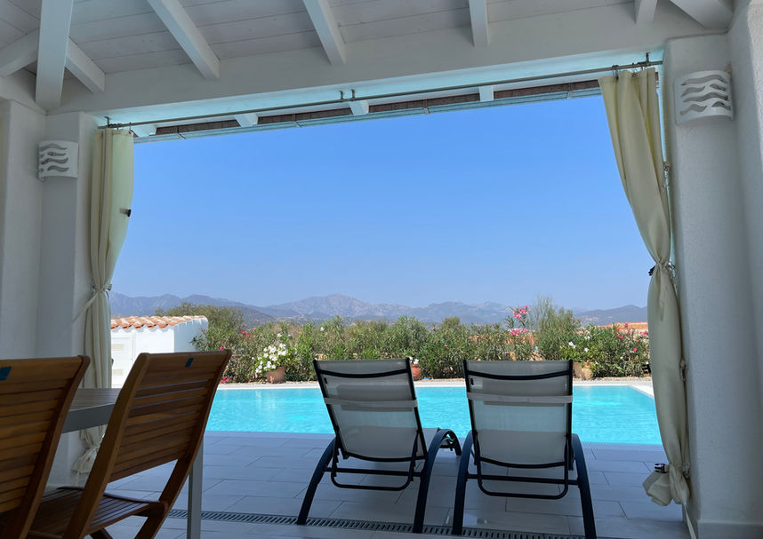 Covered terrace with seating and panoramic view of the Sardinian landscape