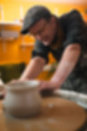 A photo of the potter working at the potter's wheel