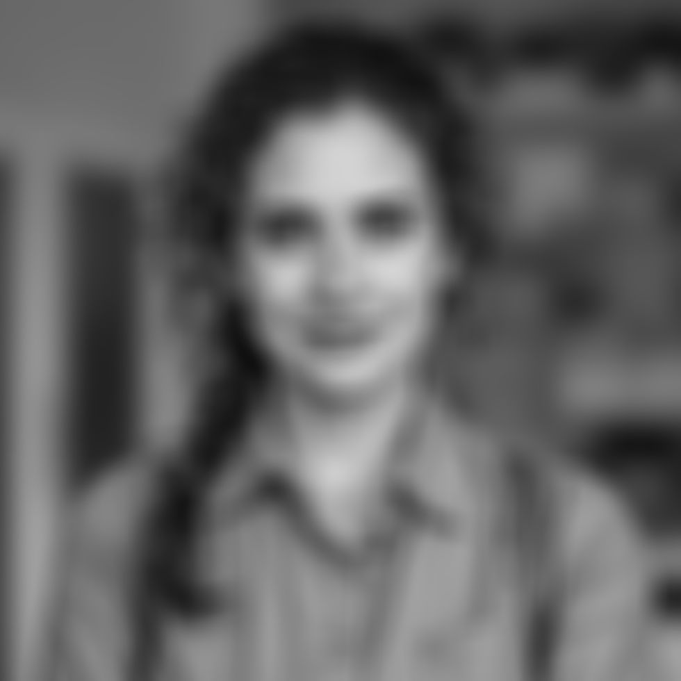 armenian woman with curly hair tied in a loose ponytail, she is a support worker for senio