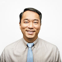 Jesse Neimus, Post-Doctoral Fellow, a winner of 2011. Jesse is smiling with short dark hair, in a white shirt and a blue tie in front of a white background.