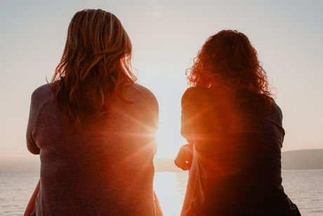 Two women with arms crossed and backs to the camera