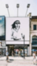 Espectacular publicitario de una mujer corriendo con lentes de sol