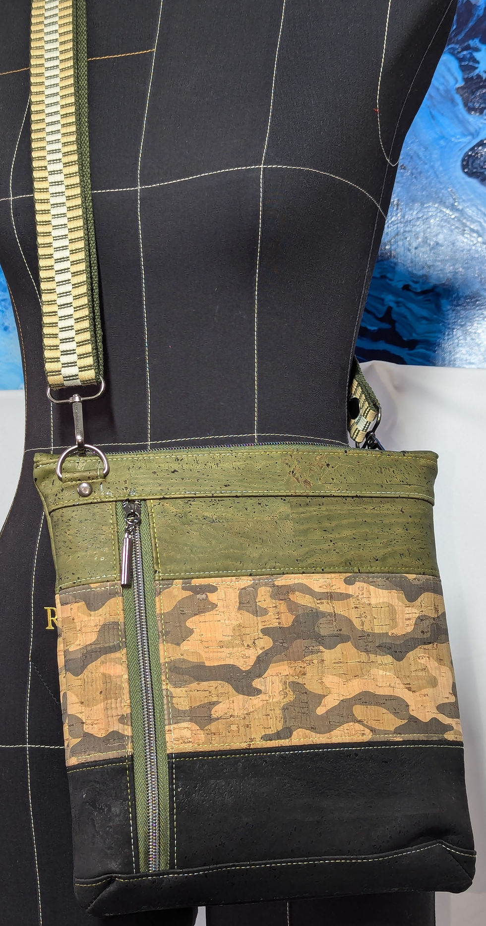 Thumbnail: Black & Camo army green 3 tone cork crossbody bag. Front view on mannequin with webbing strap in tones of light camel and army green