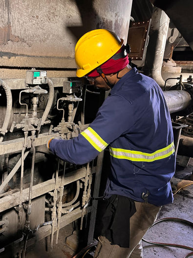 Trabajador con casco amarillo inspeccionando maquinaria industrial
