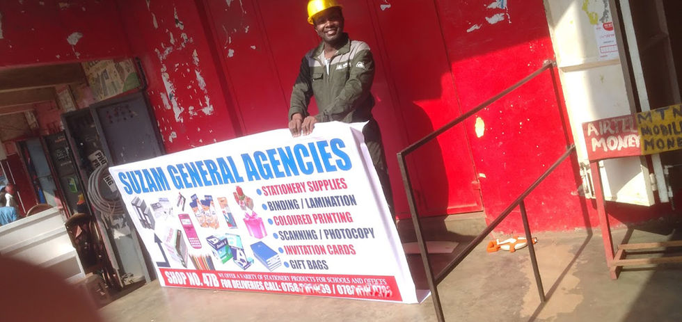 Tnka C. Muhwezi displays the FTN large-format printed banner at his workshop in Bugolobi.