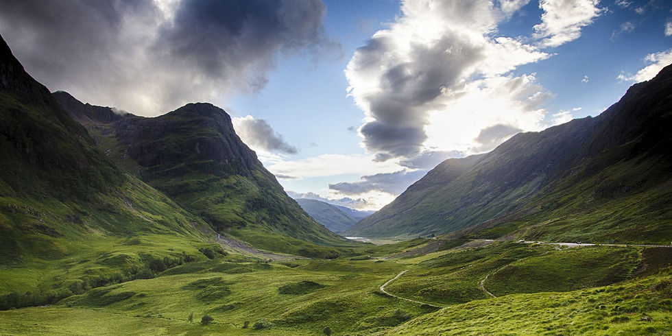 A lush, green mountainous valley in Scotland, featured in the opening scenery of the Outlander series, highlights the region's natural beauty.