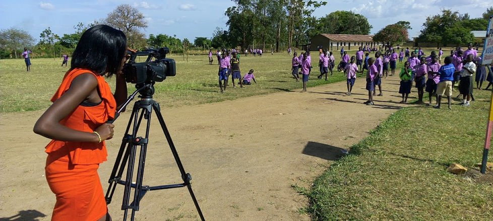 Primary school pupils at break time in West Nile, Uganda, as the FTN team member films a documentary.