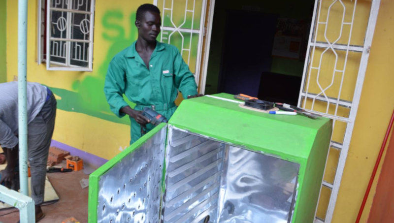 A technician drills through a metallic casing at a workshop in Kampala