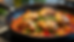 Eye-level view of a skillet with sautéed chicken thighs and vegetables