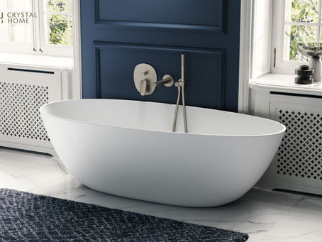 Freestanding white bathtub with brushed nickel wall-mounted faucet against a navy paneled wall in a luxury bathroom.