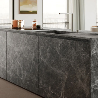 Marble-finished island kitchen with integrated sink and elegant accessories, set in a high-rise apartment.