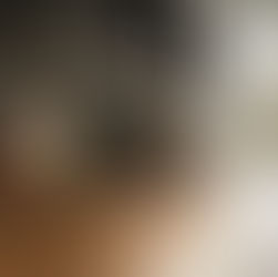 A stylish Composit kitchen featuring black upper cabinets, natural wood lower cabinets, LED under-cabinet lighting, and a matte black countertop with copper cookware.