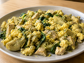 Lemon-pesto chicken egg scramble with artichokes and arugula