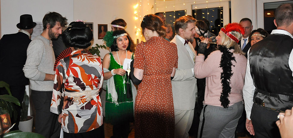 Participants conversing at a 1920s murder mystery party