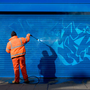 Professional team removing graffiti from a wall using eco-friendly solutions in Malta.
