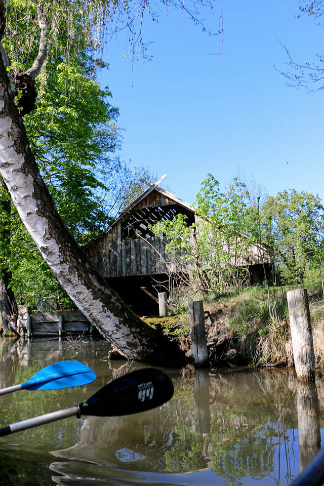 Zwei Paddel vor einem Bootshaus im Spreewald mit gekreuzten Schlangenköpfen