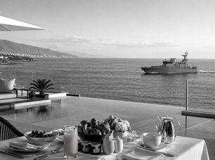Breakfast with a stunning view of the Mediterranean on the northern coast of Morocco, as a naval vessel sails by.