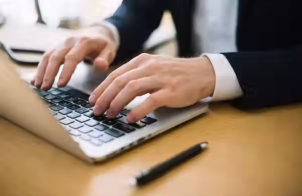 hombre-escribiendo-computadora-portatil-oficina_23-2147710995.avif