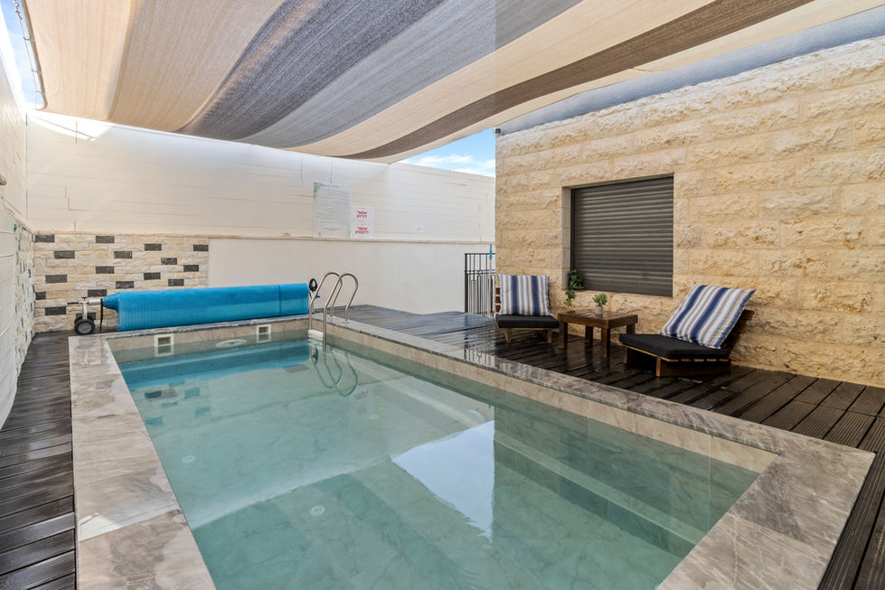 בריכת שחייה חיצונית לצד כיסאות נוח, ספא בראשית, אזור מרגיע עם נוף