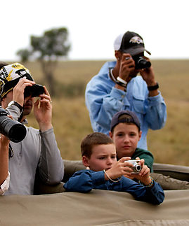 Family taking photos on safari, capturing wildlife, adventure Tours, Uganda wildlife adventure
