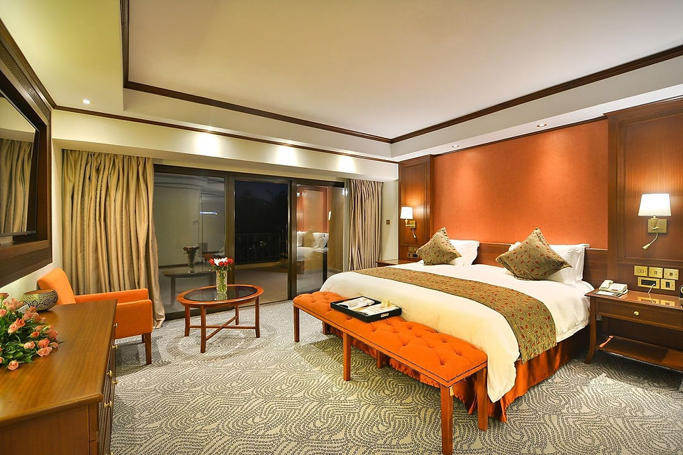 Luxury hotel bedroom with king-sized bed and seating area. Our Services include luxury stays.