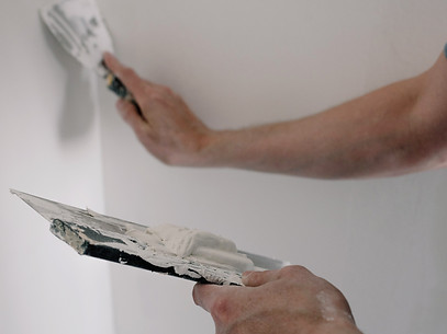 A man fixing some drywall