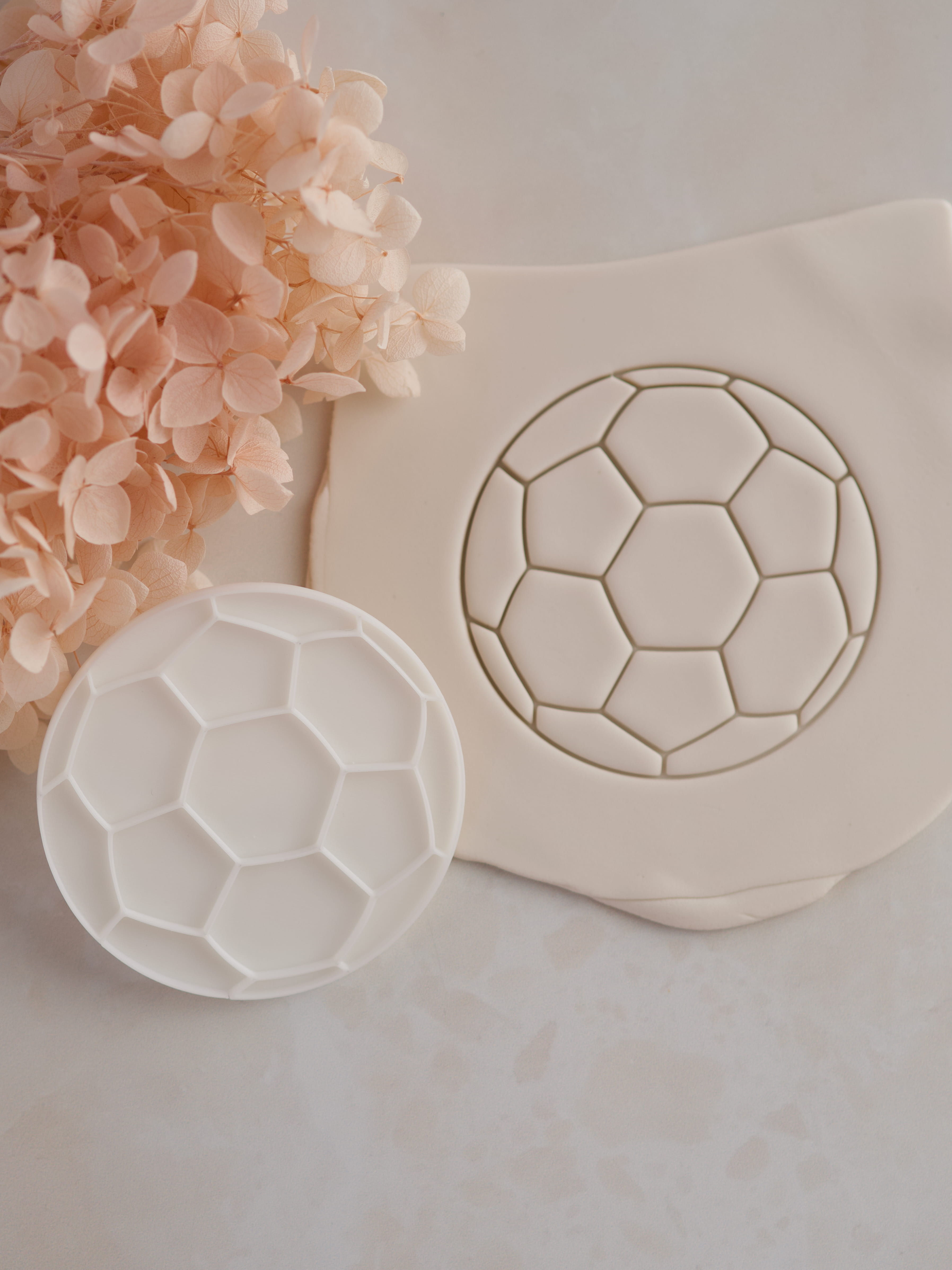 soccer ball fondant stamp embossed on white fondant round cookie