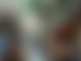 People sit at outdoor café tables along a narrow street lined with buildings.