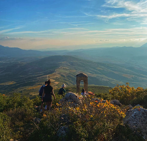 Salty sails tourists hiking with the view of a beautifull valley on a Greek island during the sail adventure