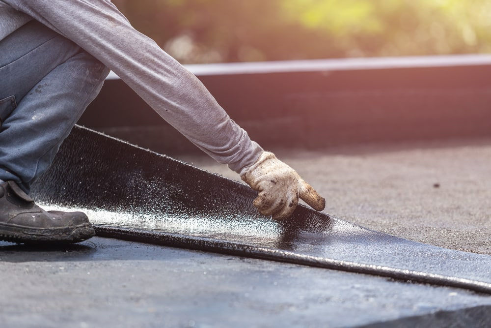 Close-up-of-roofer-installing-tar-foil-on-rooftop.jpg