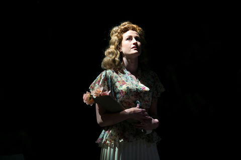 An actor stands alone in a period dress and a spotlight - A Streetcar Named Desire