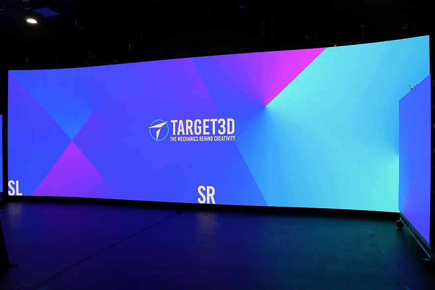An LED wall with a blue and pink background with the words Target3D The Mechanics Behind Creativity written on it