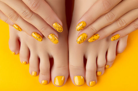 female-legs-hands-with-summer-nail-design-orange-background.jpg